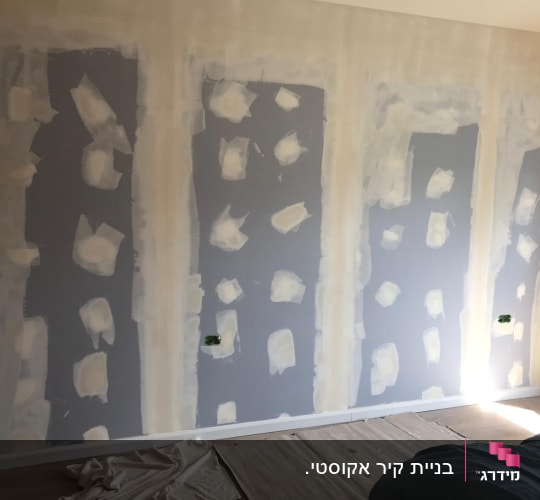 קיר עם תיקוני גבס וכתמי צבע לבנים
